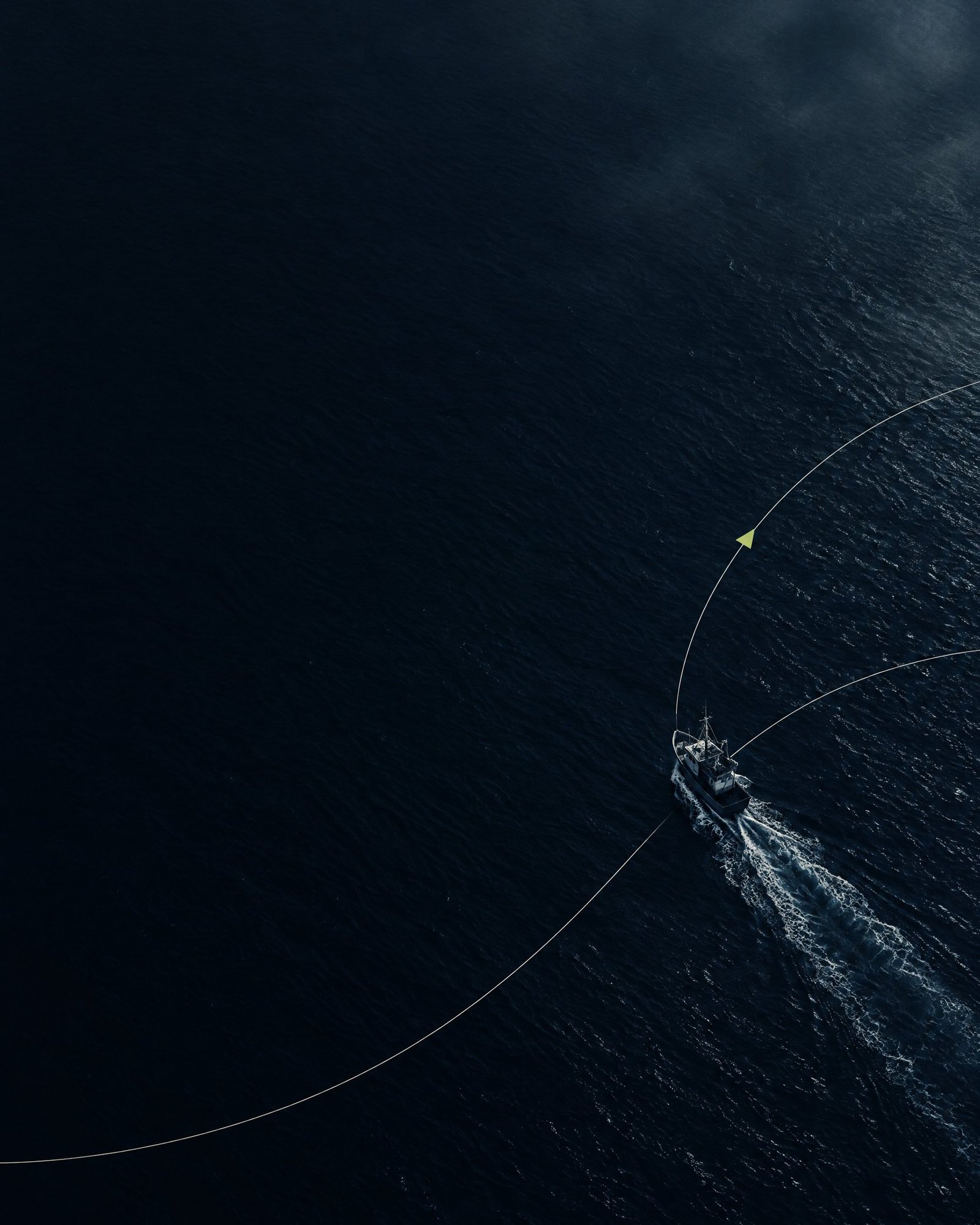 Illustrative unbranded vessel silhouette crossing dark water with a pale wake.