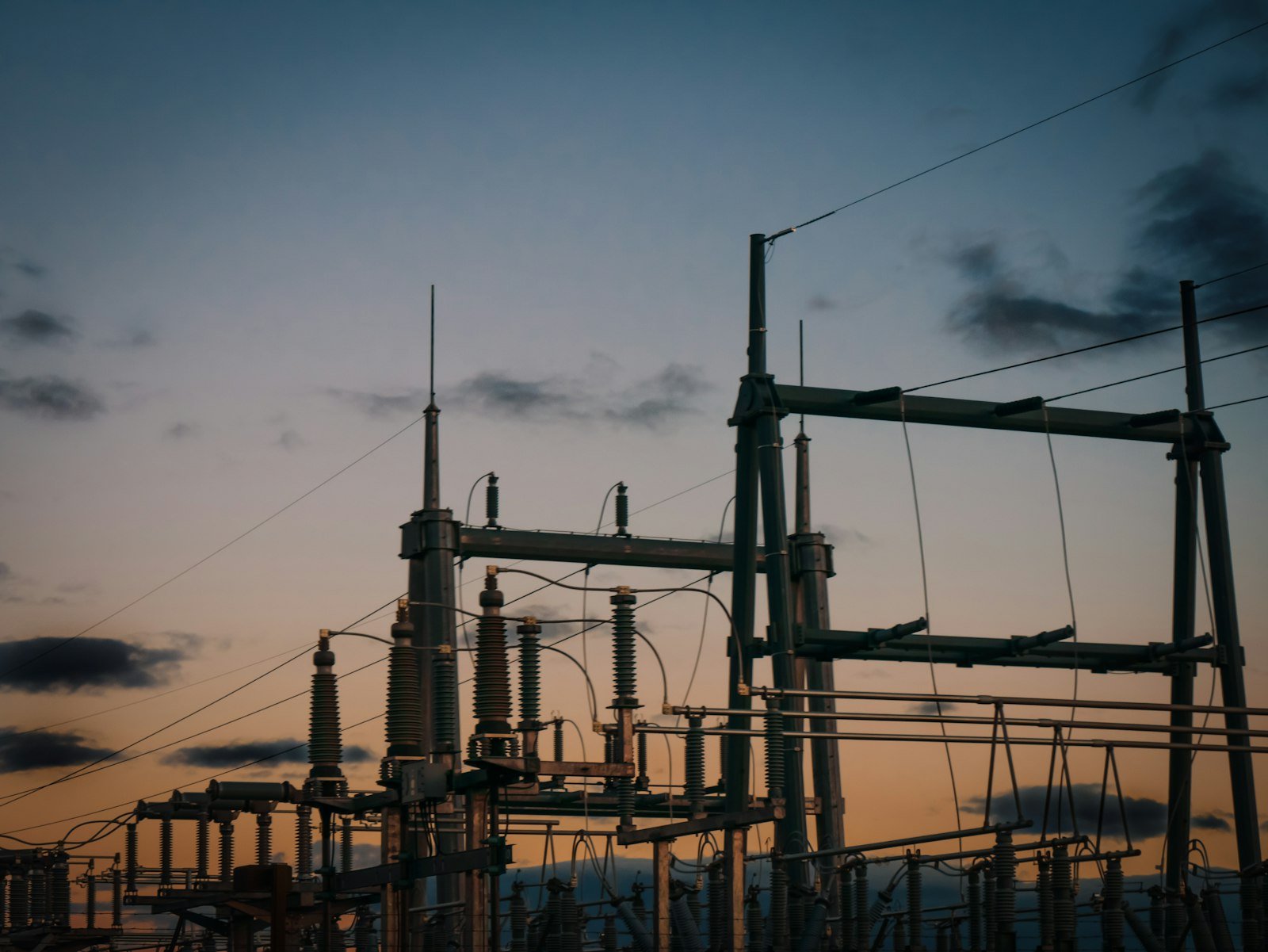 IPP payment disputes in Bangladesh: power plant chimneys and transmission lines at dusk